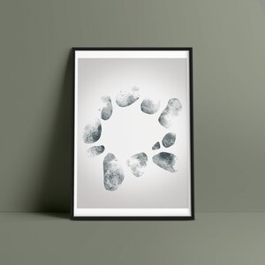 May include: A framed print featuring a watercolor design of a circular arrangement of gray and blue abstract shapes. The artwork has a minimalist style and is set against a white background within a black frame.