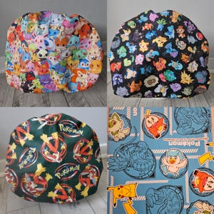 May include: Four colorful fabric hats with various Pokemon character designs. One hat features a vibrant array of characters on a white background. Another has Pokemon on a black background. The third hat is green with Pokemon logos. The fourth is a blue fabric with Pokemon.