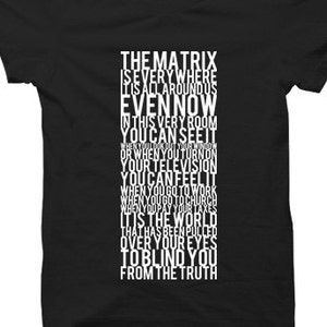 May include: Black t-shirt with white text that reads "The Matrix is everywhere it's all around us even now in this very room you can see it when you look out your window or when you turn on your television you can feel it when you go to work when you go to church when you pay your taxes it is the world that has been pulled over your eyes to blind you from the truth."