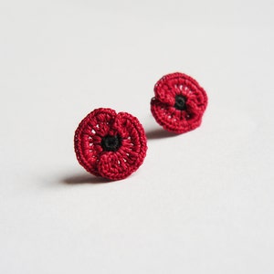 May include: A pair of red crocheted poppy earrings. The earrings are small and delicate, and they would make a beautiful gift for someone who loves poppies.