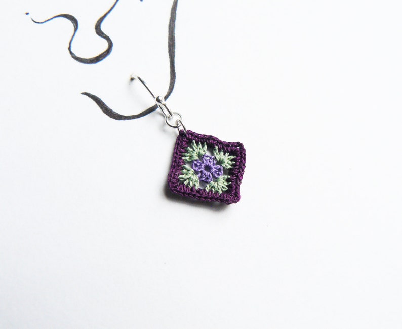 May include: Purple crochet earring with a green and purple flower design.