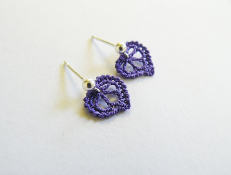 May include: A pair of purple crocheted leaf earrings with silver posts and beads.