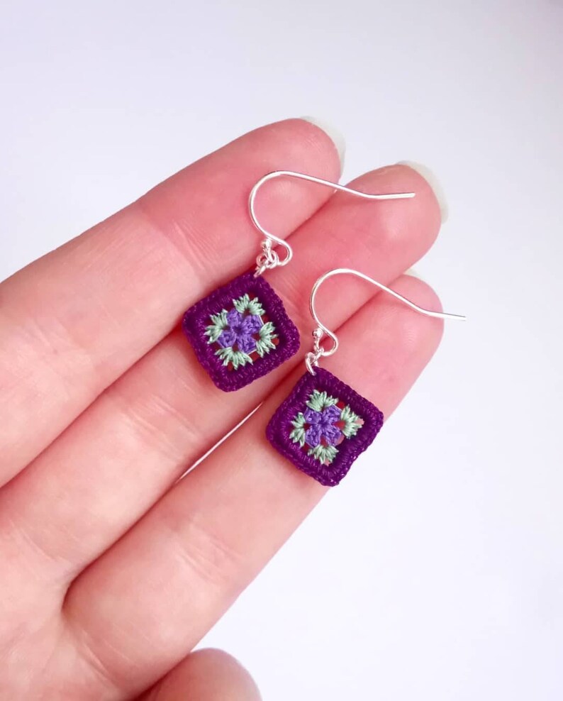 May include: Purple and green crochet square earrings with silver hooks.