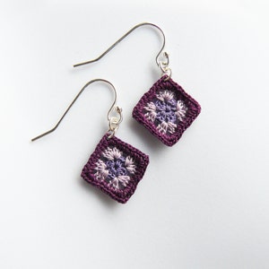 May include: A pair of purple and lavender crochet earrings with silver hooks.