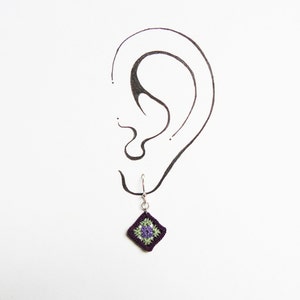 May include: Crocheted purple and green square dangle earrings with a silver hook.