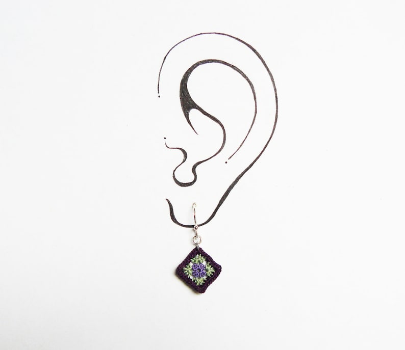 May include: Crocheted purple and green square dangle earrings with a silver hook.