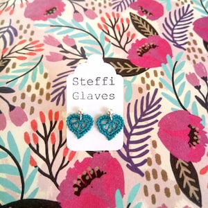 May include: Teal crochet heart earrings with silver hooks on a white card with the text "Steffi Glaves".
