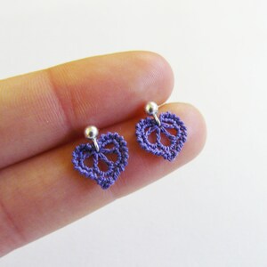 May include: A pair of purple crocheted heart-shaped earrings with silver posts.