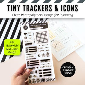May include: A clear photopolymer stamp set labeled Tiny Trackers & Icons by Creative Planner Vibes. The sheet includes various grid trackers, checklists, water drop icons, and small symbols like a heart, moon, and camera for planner organization.