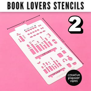 K&ouml;nnte beinhalten: Eine wei&szlig;e rechteckige Schablonenplatte mit der Aufschrift BOOK LOVERS STENCILS und der Zahl 2. Sie enth&auml;lt verschiedene Ausstanzungen wie Sterne, Herzen und Rechtecke. Die Ma&szlig;e sind mit 7,29 cm mal 14,02 cm angegeben, mit kleineren Ausschnitten von 2,51 cm.