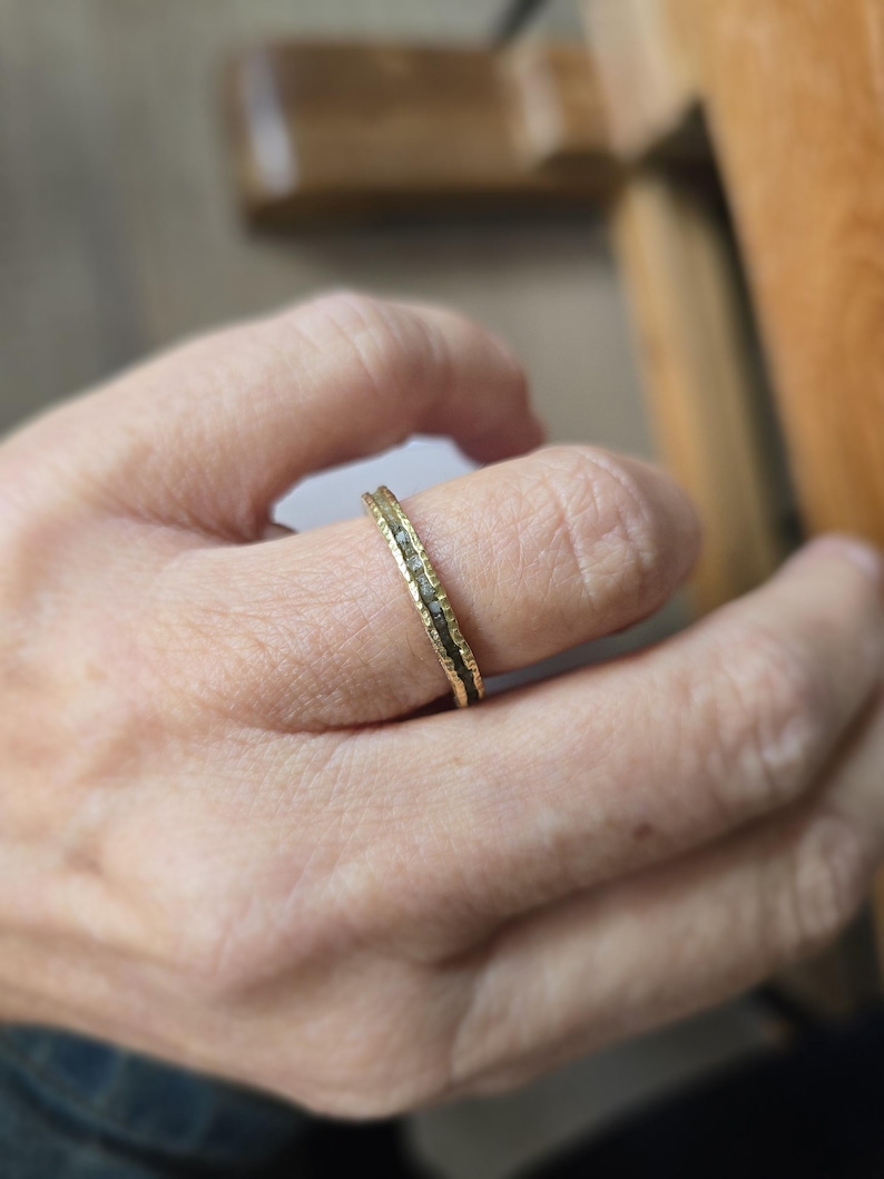 Pu&ograve; includere: Un anello a fascia d'oro con una fila di piccoli diamanti incastonati al centro.