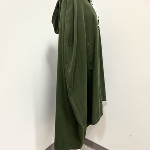 May include: A dark green hooded cape with a long, flowing design. The cape is made of a soft, comfortable fabric and has a simple, elegant style.