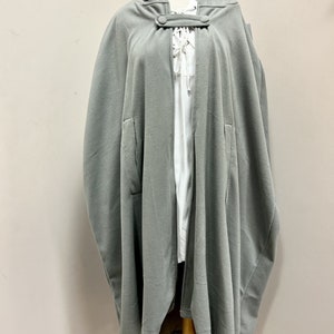 May include: A gray hooded cape with a button closure and a lace-up detail at the neck.