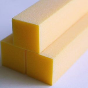 May include: Three yellow rectangular foam blocks stacked on top of each other.