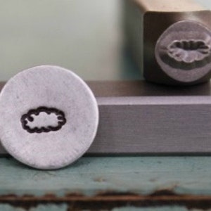 May include: A silver metal stamp with a design of a cloud. The stamp is used for creating impressions on metal.
