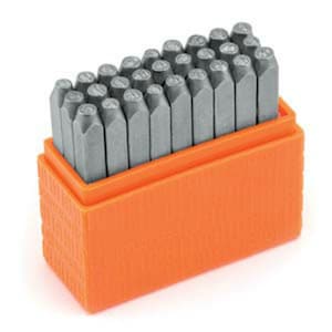 May include: A set of metal letter stamps in an orange plastic case. The stamps are arranged in rows and are ready to be used for stamping letters and numbers.