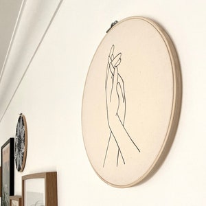 wall decor embroidery hoop of holding hands on canvas.