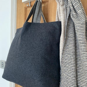 Dark grey tote bag with herringbone handles.