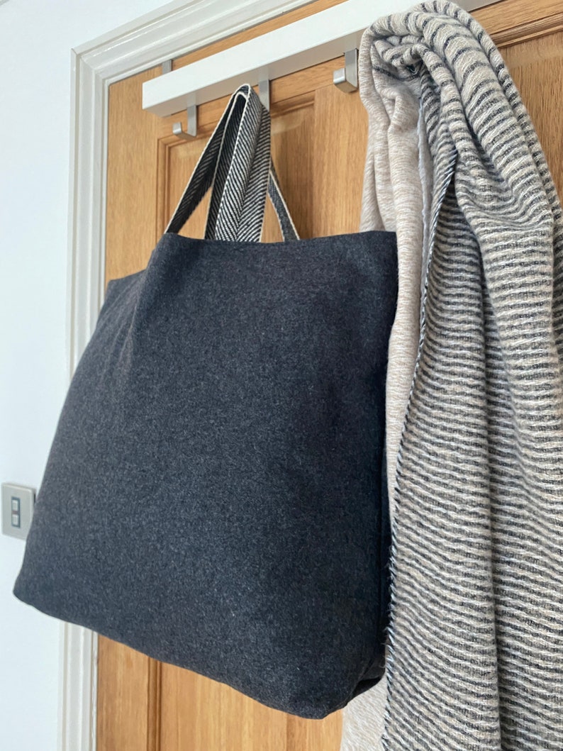 Dark grey tote bag with herringbone handles.