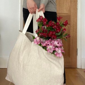 Extra large Natural Jute tote bag shown with red and pink flowers.