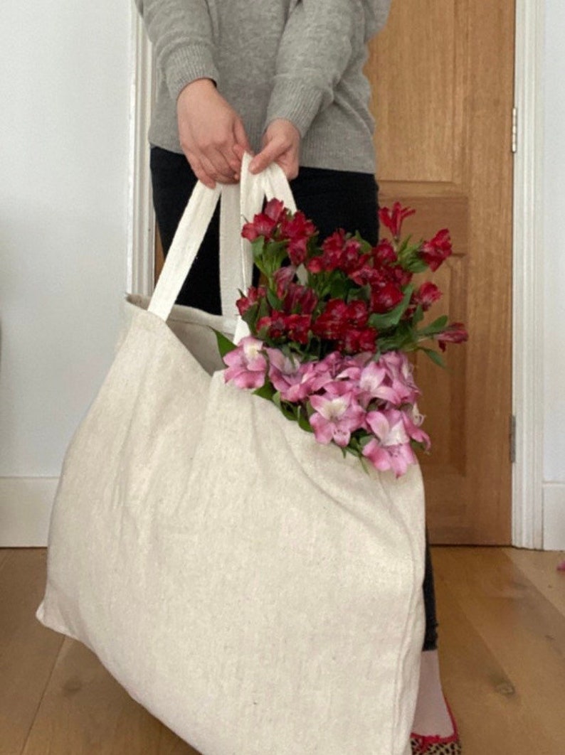 Extra large Natural Jute tote bag shown with red and pink flowers.