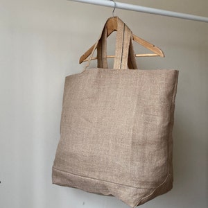 Extra large Natural Jute tote bag on wooden hanger.