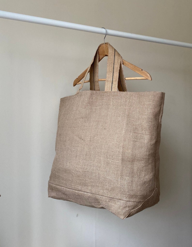 Extra large Natural Jute tote bag on wooden hanger.