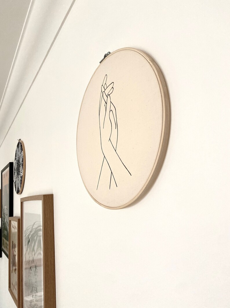 wall decor embroidery hoop of holding hands on canvas.