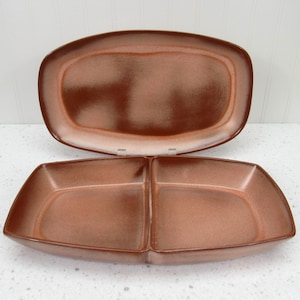 May include: Two-piece serving dish set. The set includes a large, rectangular platter and a divided serving dish. Both pieces have a speckled, brown glaze with a lighter rim. The dishes are likely made of ceramic or stoneware.