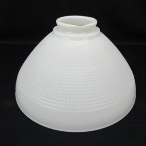 Könnte beinhalten: Ein weißer Lampenschirm aus Glas in Kuppelform mit einem strukturierten Gittermuster auf der Oberfläche. Der Schirm verfügt über eine kreisförmige Öffnung an der Oberseite mit einem erhöhten Rand zur Befestigung an einer Leuchte und einen breiten, glatten Boden.