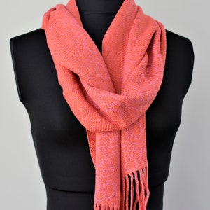 Bold coral and rose handwoven bamboo scarf with subtle fancy diamond pattern. 6.5 inches wide by 74 long, drapes beautifully. Finished with hand-braided fringe.