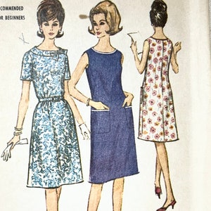 Könnte beinhalten: Vintage McCall's Schnittmuster für ein Halbgrößen- und Damenkleid. Das Schnittmuster ist für ein ärmelloses Kleid mit Tasche und ein Kleid mit kurzen Ärmeln und einem Blumendruck. Das Schnittmuster ist mit "Easy to Sew" gekennzeichnet und für Anfänger geeignet. Die Schnittmuster-Nummer ist 7229.