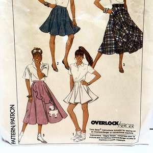 Puede incluir: Patrón de costura Simplicity número 8629 talla H (6-8-10) para una falda. El patrón muestra cuatro estilos de faldas diferentes: una falda blanca con un cinturón negro, una falda a cuadros con un cinturón negro, una falda blanca con una camiseta de tenis y una falda rosa con un diseño de caniche. El patrón incluye instrucciones para coser en una remalladora o una máquina de coser convencional.