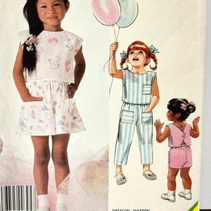 Könnte beinhalten: McCall's Easy Nähmuster Nummer 2362 für Kinderkleidung. Das Muster enthält drei verschiedene Outfits: ein rosa-weißes Kleid mit passendem Rock, einen blau-weiß gestreiften Overall und ein rosa ärmelloses Oberteil mit passender Shorts.
