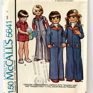 Puede incluir: Un patrón de costura para un mono para niños pequeños y niños con una transferencia de hierro a todo color de Raggedy Ann y Raggedy Andy. El patrón es de McCall's y es el número 5641.