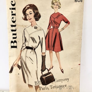 Op de afbeelding: Vintage naaipatroon voor een jurk, Butterick patroonnummer 9895, maat 14, borstomvang 86 cm. Het patroon toont twee vrouwen in jurken, een in wit en een in rood. Het patroon is van de Bell Company in Paris, Tennessee.