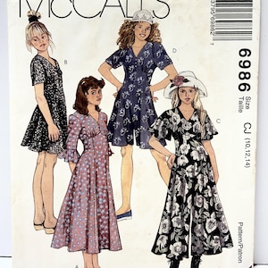 Könnte beinhalten: McCall's Schnittmuster mit Illustrationen von vier verschiedenen Kleidern. Die Modellnummer ist 6986, Größen CJ (10, 12, 14). Die Kleider umfassen einen schwarz-weißen Blumendruck, einen blauen Blumendruck und ein rosa gepunktetes Kleid.