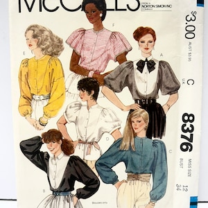 May include: Vintage McCall's sewing pattern with blouse illustrations. The cover displays diverse blouse designs in various colours and styles, including a yellow, pink striped, and blue blouse. The pattern number is 8376.