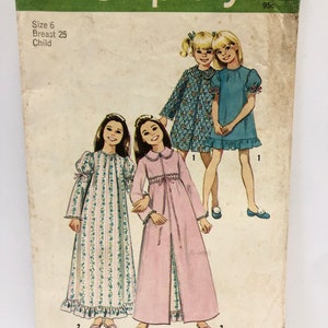 Könnte beinhalten: Vintage Simplicity Schnittmuster Nummer 5339 für ein Nachthemd für Kinder. Das Schnittmuster umfasst zwei Stile: ein langärmliges Nachthemd mit einem Rüschen-Saum und eine langärmlige Robe mit einem Bindegürtel. Das Schnittmuster ist auf weißem Papier mit grünem Rand gedruckt und enthält Anweisungen für die Größen 6 (25 Zoll Brustumfang).