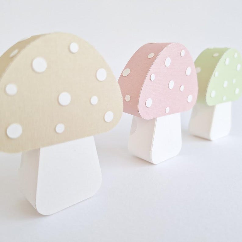 Pode incluir: Tr&ecirc;s cogumelos de papel com bolinhas brancas. Os cogumelos s&atilde;o bege, rosa e verde.