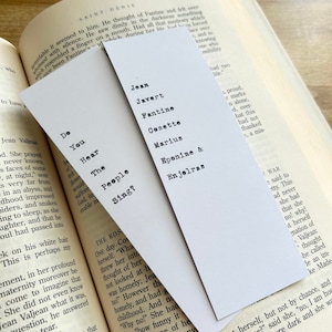 Puede incluir: Un conjunto de tres marcapáginas blancos con texto negro. Los marcapáginas presentan citas del musical Los Miserables. El primer marcapáginas dice "Do You Hear The People Sing?" El segundo marcapáginas enumera los nombres de los personajes del musical: Jean Javert, Fantine, Cosette, Marius, Eponine & Enjolras. El tercer marcapáginas dice "4 proud, e marks n alone, d, over- hat this had not thanked , a mis- 3 WAR e said to tty. This ad never she had that she no! why! it herself nation of Valjean: thought he called le an im- ke Made"