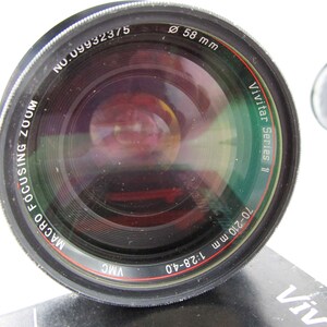 May include: A black Vivitar Series 11 70-210mm 1:2.8-4.0 macro focusing zoom lens with a 58mm filter thread. The lens has a red and white ring around the barrel.