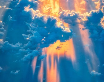 Ariel painterly style photograph of god rays filtering through clouds to provide an angelic and heavenly appearance.