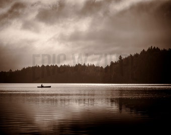 Sepia style photograph of iconic Adirondack mountain lake with canoe. Photograph near Rollins Pond and Fish Creek Pond.