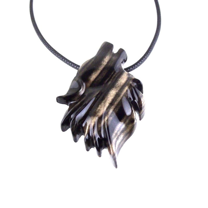 A black with brown streaks wooden pendant shaped like a wolf's head, hanging from a black cord necklace.