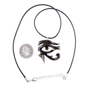 A wooden eye of Horus pendant necklace with a black cord. The necklace is made of wood and has a black and light brown color grain.