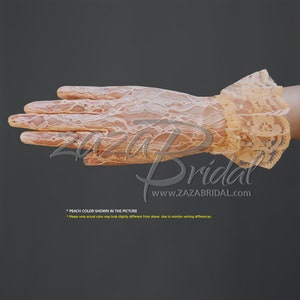 Peut inclure: Gants en dentelle de couleur pêche avec un poignet bouffant. Les gants sont transparents et délicats, avec un motif floral. Le texte "Bridal" et "www.zazabridal.com" est visible sur l'image.