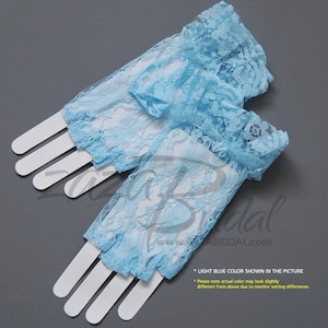 May include: A pair of light blue lace gloves with a ruffled edge. The gloves are made of delicate lace and have a sheer, airy feel. The gloves are perfect for adding a touch of elegance to any outfit.