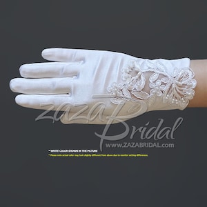 Puede incluir: Guantes de novia de satén blanco con un diseño de encaje floral en el dorso de la mano. El encaje presenta detalles de perlas.