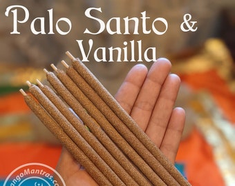 May include: A hand holds several Palo Santo & Vanilla incense sticks. The sticks are a light brown color and have a textured surface. The text "Palo Santo & Vanilla" is at the top of the image. The logo for MangoMantras.com is in the lower left corner.